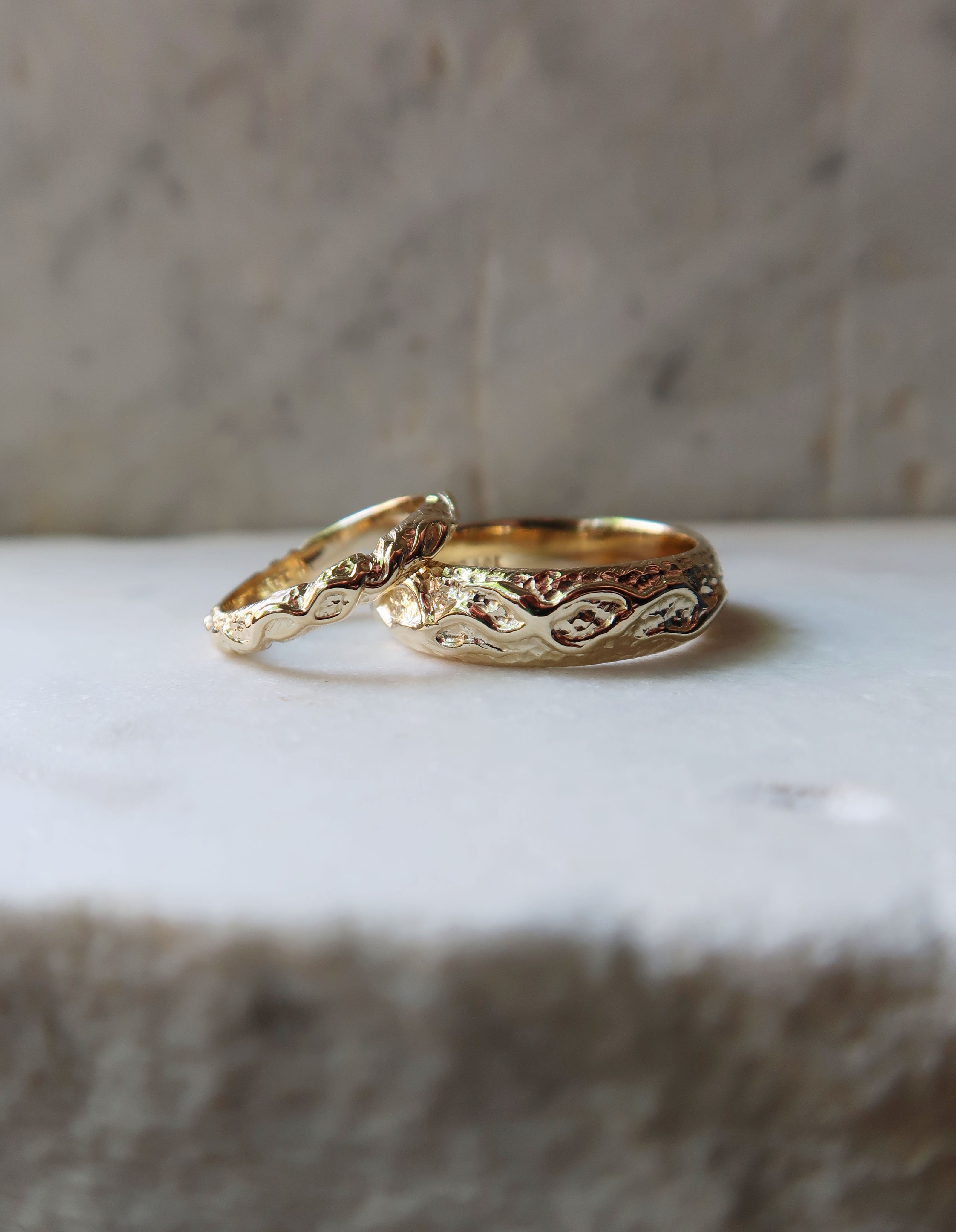 Two custom design and handcrafted wedding bands for man and woman in gold.