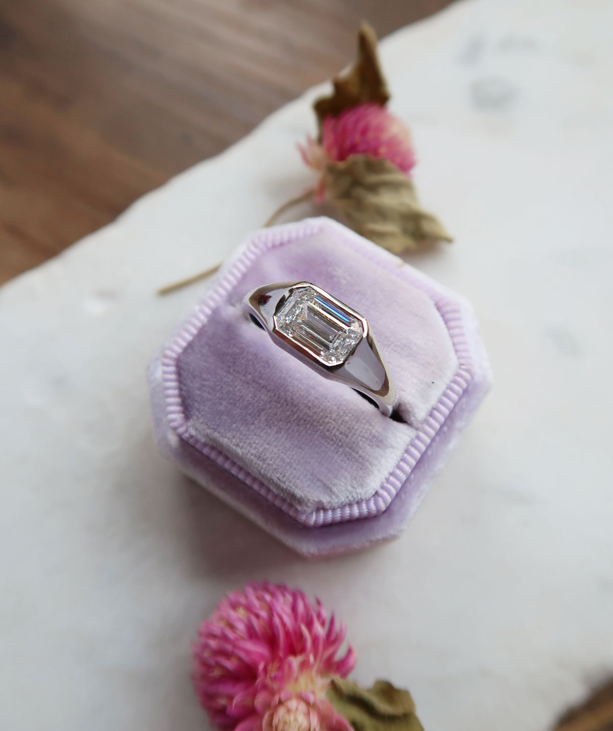 A pair of tailor-made, 14k white gold engagement rings! The first ring features a juicy, emerald cut lab diamond in an elegant and seamless bezel setting, while the second ring is a sleek signet style with a flush set lab diamond baguette! Both rings are perfect for everyday wear. Clean lines and minimalism for the win! 