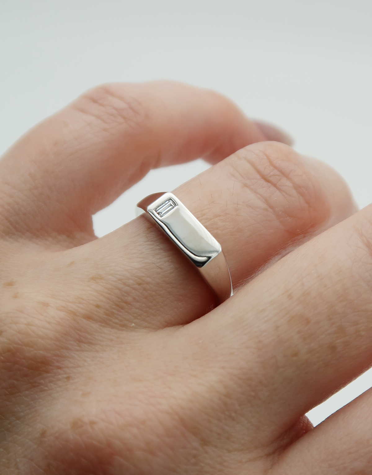 A pair of tailor-made, 14k white gold engagement rings! The first ring features a juicy, emerald cut lab diamond in an elegant and seamless bezel setting, while the second ring is a sleek signet style with a flush set lab diamond baguette! Both rings are perfect for everyday wear. Clean lines and minimalism for the win! 