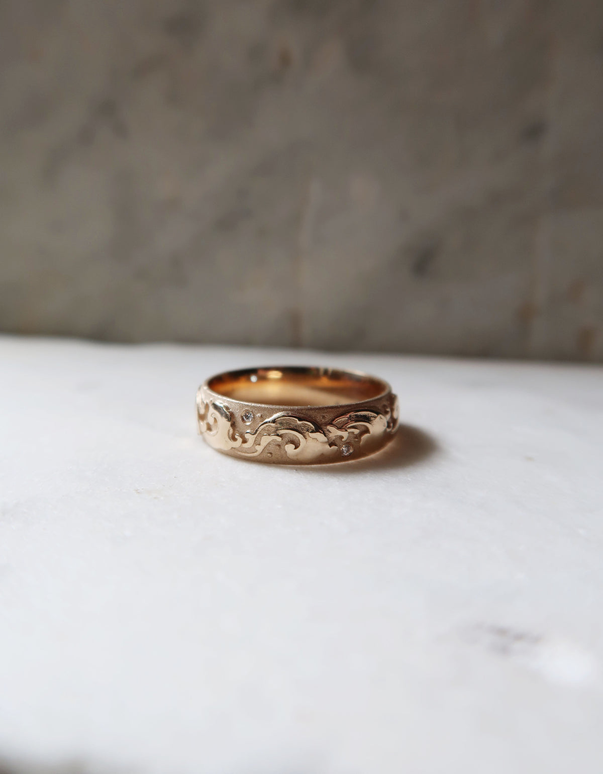This incredible 14k yellow gold and diamond wedding band is full of movement and personality. Featuring a classic tattoo style wave design, the recessed areas of the ring have been sandblasted, while the raised waves are high-polished, adding texture and depth to the piece.