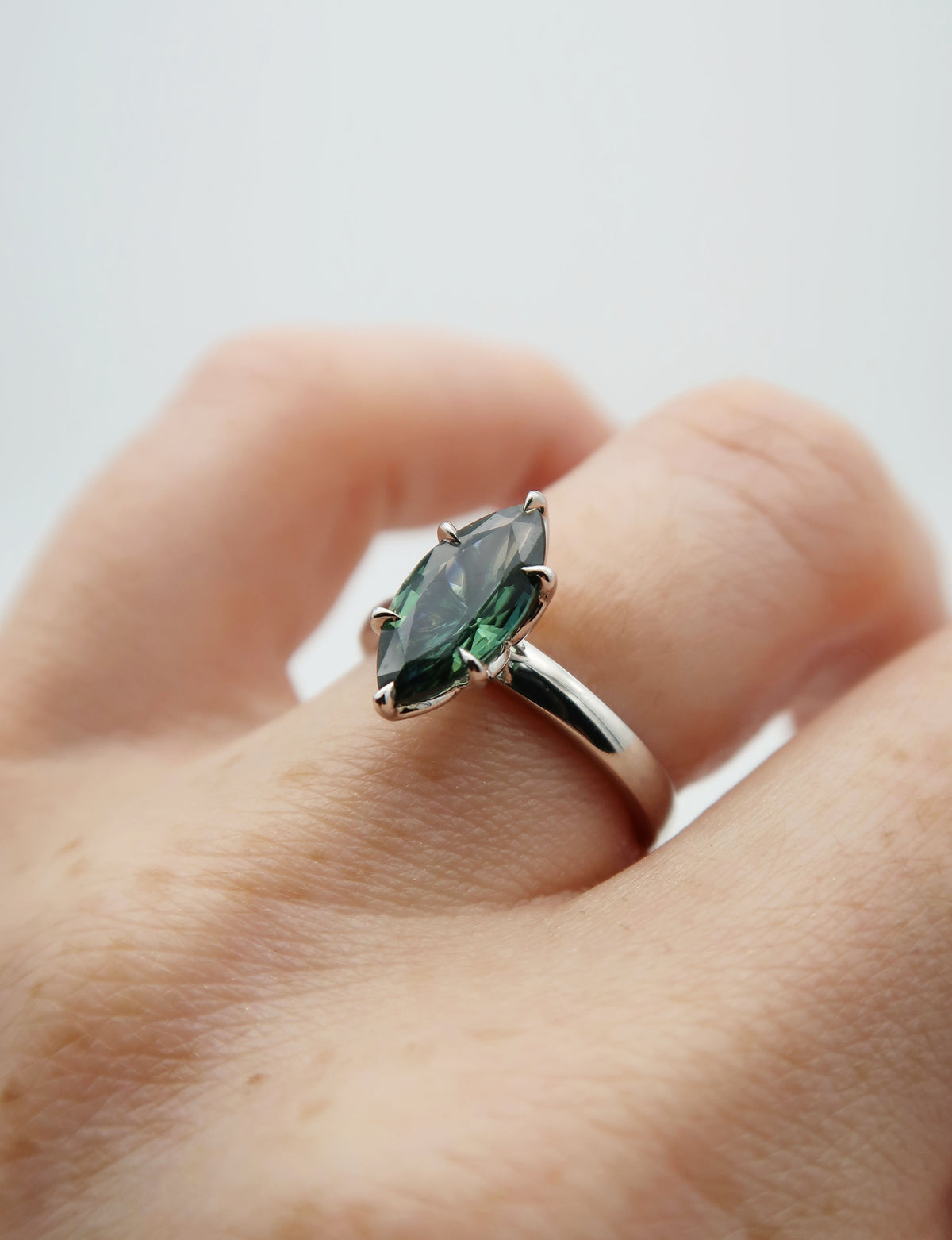 Elegant and minimal, this custom 14k white gold and teal marquise sapphire engagement ring was inspired by the bride and groom’s favourite secluded spot on a lake. So romantic!